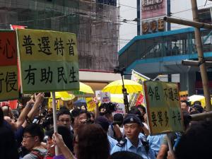 Signs: &quot;Universal Suffrage in Chief Executive Election Helps People’s Welfare&quot; (left) and &quot;If Not Passed Now, 10 More Years of Waiting,&quot; at the &quot;The Citizens Against Pseudo-Universal Suffrage&quot; march, Hong Kong, June 14, 2015. HRIC photo.