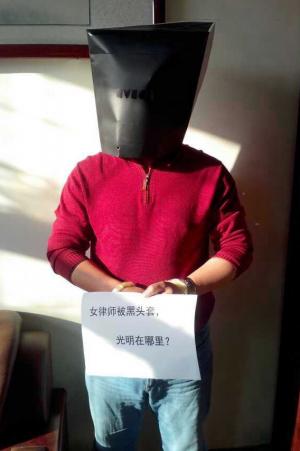 Online performance art campaign initiated by women human rights defenders to protest the thug-like treatment of lawyer Wang Shengsheng. Placards read: &quot;Women lawyers in black hoods, where is the light?&quot;